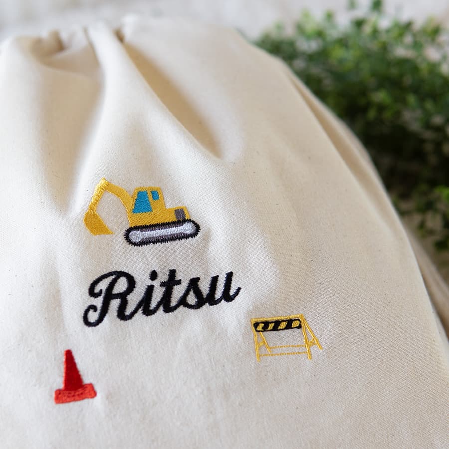 刺繍名入れ 1歳誕生日 一升餅 名前入りリュック・生成り・ショベルカー
